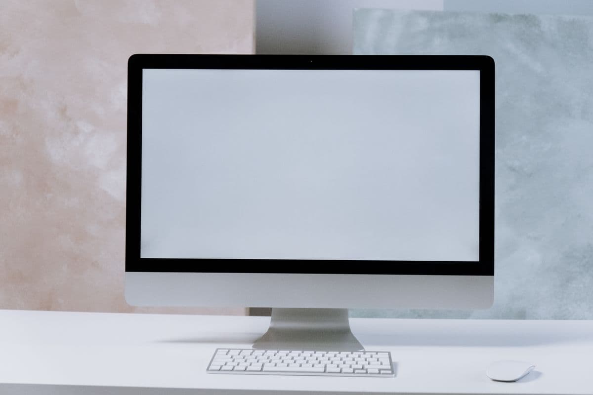 iMac on a clean white desk with keyboard and mouse