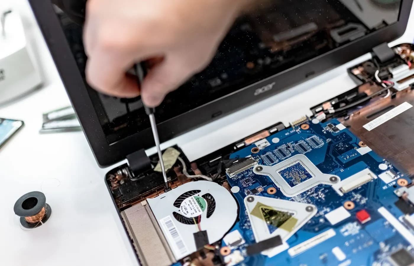 Technician repairing a laptop motherboard for a customer in Dubai