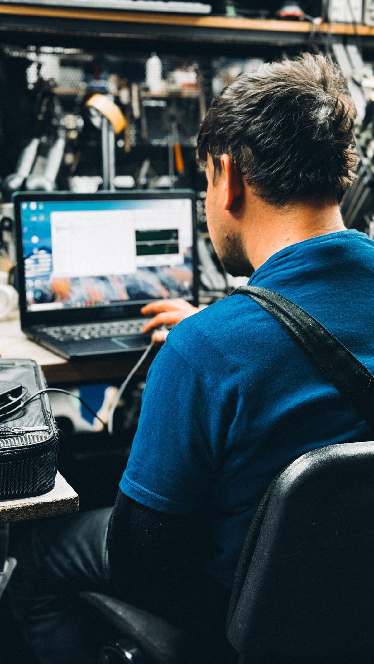 Technician repairing a laptop at an office desk