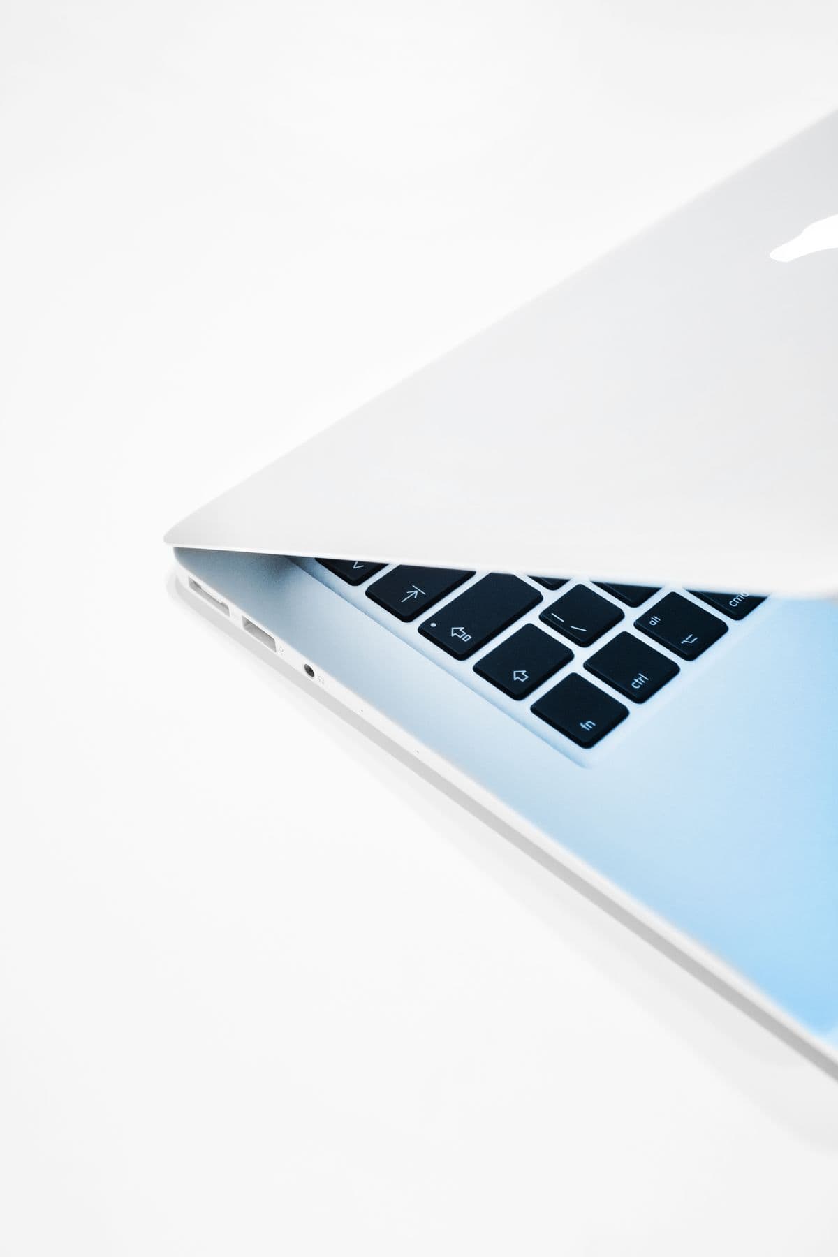 MacBook laptop half open on a white desk